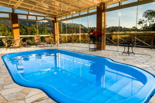 a swimming pool in the middle of a house at Pousada Suiça Mineira Centro in Monte Verde