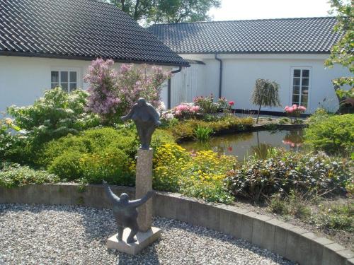 a statue of two children on a pedestal in a garden at Best Bed in Herning