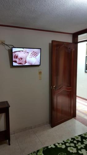a flat screen tv hanging on a wall next to a door at Nuevo Horizonte in Pasto