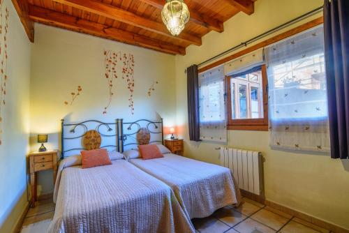 a bedroom with a bed in a room with windows at Apartamentos Rurales Balcón Real Senda del Oso in Campiello
