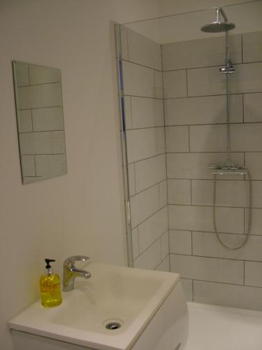 a white bathroom with a sink and a shower at Stratford Apartment in Newmarket