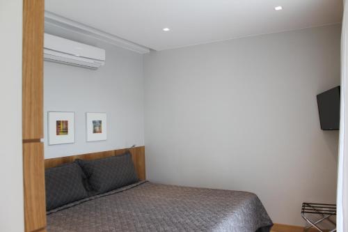 a bedroom with a bed and a flat screen tv at Grande Hotel Petrópolis in Petrópolis