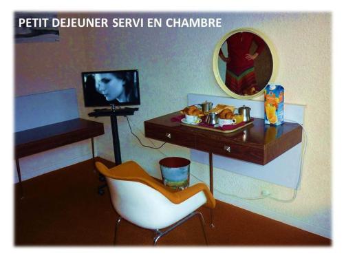 Habitación con escritorio, silla y TV. en La Darentasia, en La Léchère