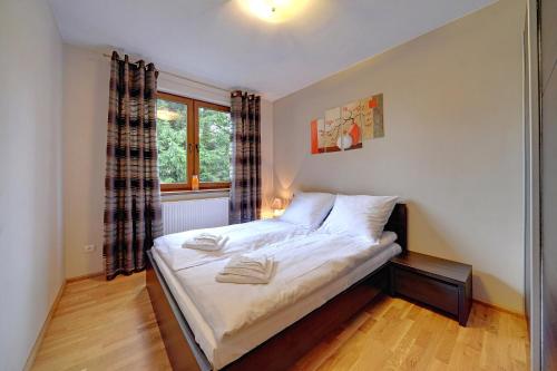 małą sypialnię z łóżkiem z oknem w obiekcie Przytulny i Gustowny Apartament Sun Seasons 24 w Karpaczu by Noclegi Renters w mieście Karpacz