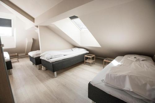 a bedroom with two beds and a sloped ceiling at Stavanger Housing Hotel in Stavanger