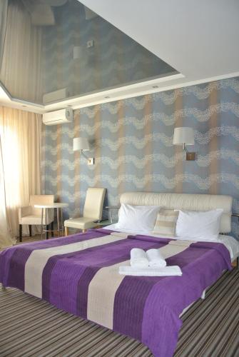 キーウにあるMini Hotel on Poznyakyのベッドルーム1室(大型ベッド1台、タオル2枚付)