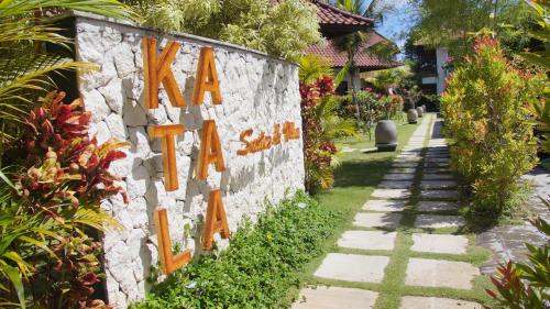 a stone wall with a sign that saysana salt at Katala Suites and Villas in Sanur