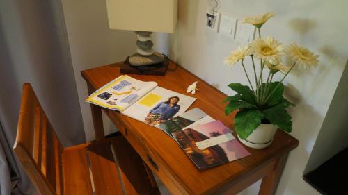 a wooden desk with a vase of flowers on it at Katala Suites and Villas in Sanur