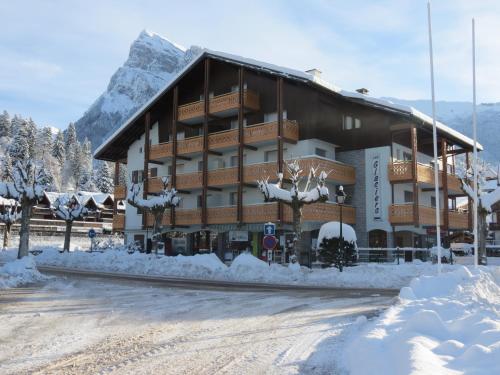 un bâtiment recouvert de neige avec une montagne en arrière-plan dans l'établissement Résidence Les Glaciers, à Samoëns