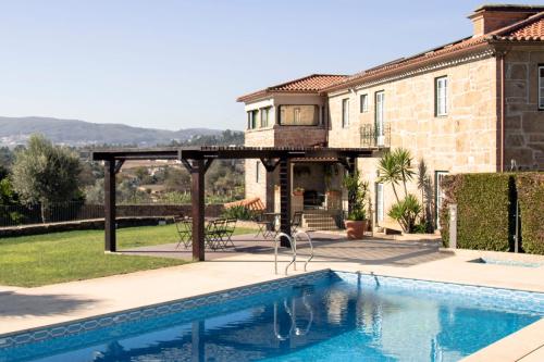 a house with a swimming pool in front of a house at Casa da Pousada in Barcelos