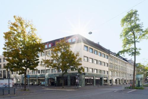 a large building with a clock on the front of it at Hotel City Zürich Design & Lifestyle in Zurich