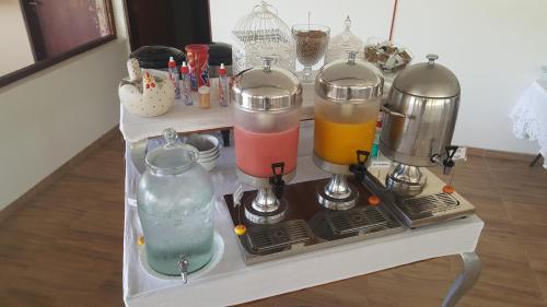 een tafel met drie verschillende gekleurde drankjes in flessen bij Fazenda Fiore Resort in Paripueira