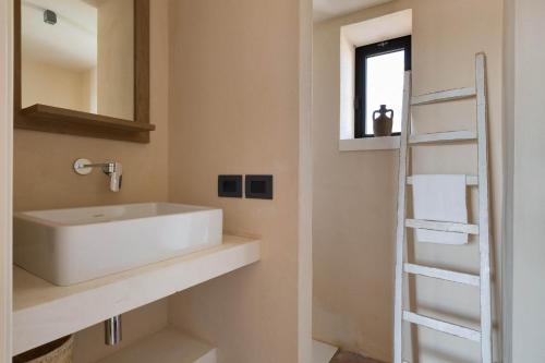 een badkamer met een witte wastafel en een ladder bij Casale Cimino by BarbarHouse in Ostuni