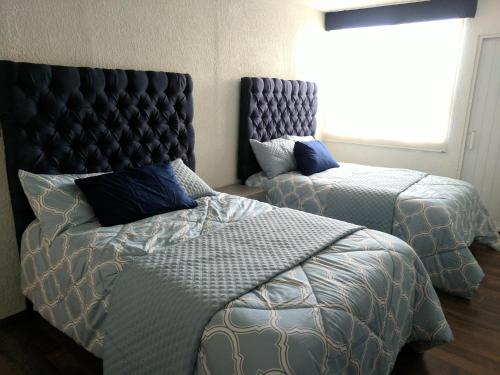 マサトランにあるAmplio Condominio Ibis Mazatlán Zona doradaのベッドルーム1室(ベッド2台、ヘッドボード付)