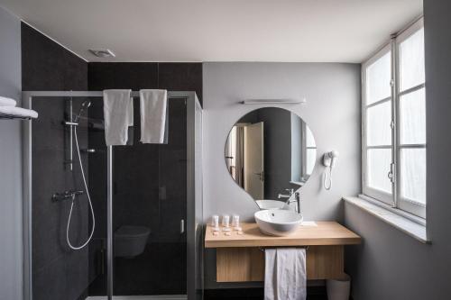 a bathroom with a sink and a shower with a mirror at Stay Hotel Évora Centro in Évora