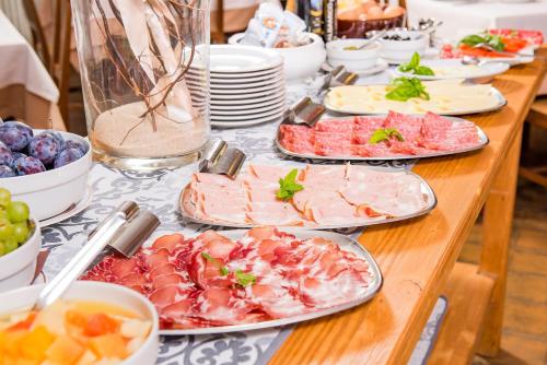 a table with many plates of food on it at Hotel Taormina in Bardolino