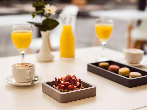 two glasses of orange juice and a tray of breakfast food at Esplendor by Wyndham Asuncion in Asuncion