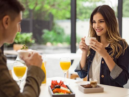 a man and a woman sitting at a table eating food at Esplendor by Wyndham Asuncion in Asuncion