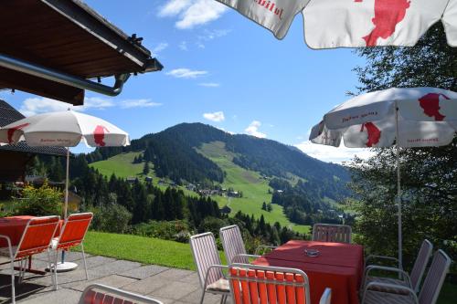 a table and chairs with a view of a mountain at Gasthof Hotel IFENBLICK in Sibratsgfäll