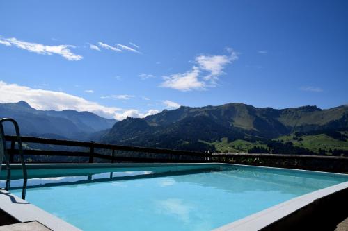 a swimming pool with a view of mountains at Gasthof Hotel IFENBLICK in Sibratsgfäll