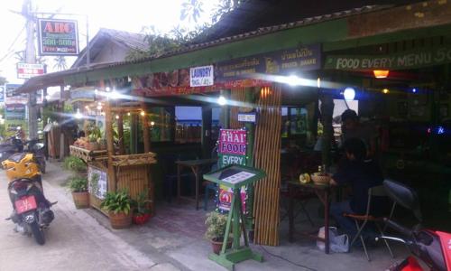 a store with a motorcycle parked in front of it at ABC Bungalow in Baan Tai