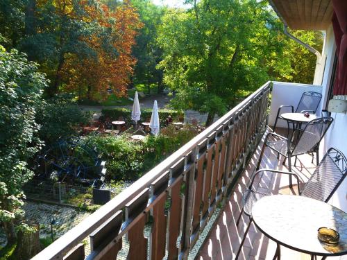a balcony with tables and chairs and a view of a garden at Hotel und Weingut Karlsmühle in Mertesdorf