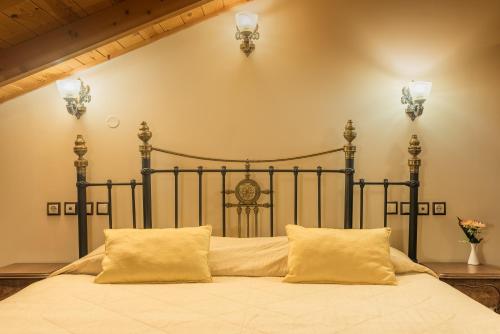 a bedroom with a large bed with two pillows at Theofilos Paradise Boutique Hotel in Mytilini
