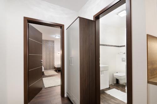 ein Badezimmer mit einem Spiegel, einem WC und einem Waschbecken in der Unterkunft Paulay Downtown Apartments in Budapest