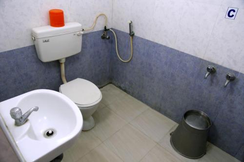 a bathroom with a toilet and a sink at Hotel Suriyapriya in Cuddalore