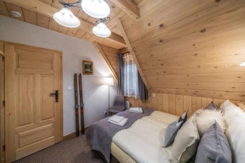 a bedroom with a bed and a wooden ceiling at Cyrhlica House in Chochołów