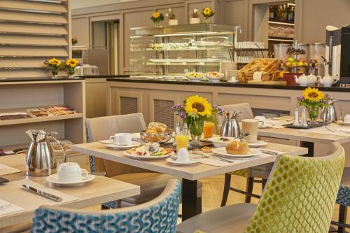 a restaurant with tables and chairs with food on them at H4 Hotel Residenzschloss Bayreuth in Bayreuth