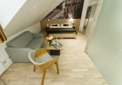 a living room with a bed and a couch at Garni hotel Castle Bridge in Český Krumlov
