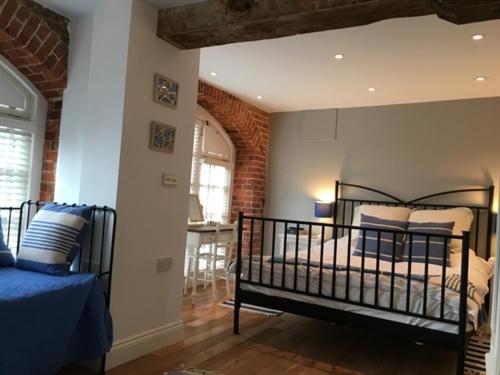 1 dormitorio con cama y pared de ladrillo en Stoneleigh Barn Bed and Breakfast, en Sherborne