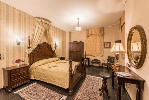 a bedroom with a bed and a desk and a mirror at Theofilos Paradise Boutique Hotel in Mytilini