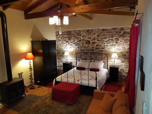 1 dormitorio con cama y pared de piedra en Theopetra, en Theópetra