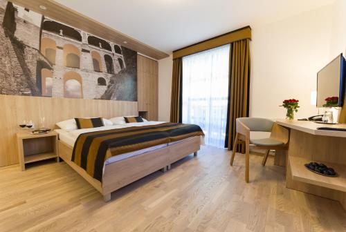 a hotel room with a bed and a desk with a computer at Garni hotel Castle Bridge in Český Krumlov