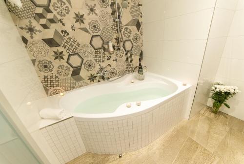 a bath tub in a bathroom with a tile wall at Garni hotel Castle Bridge in Český Krumlov