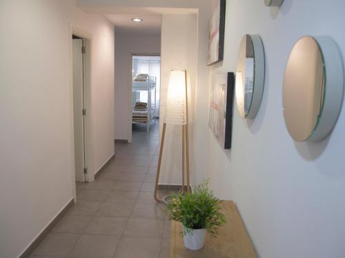 a hallway with two mirrors on the wall and a plant at Flats Friends Tetuan in Valencia