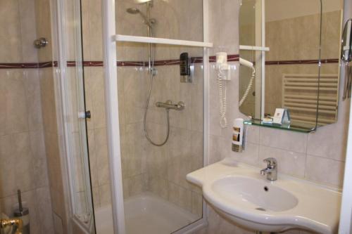a bathroom with a shower, sink, and toilet at Hotel Reuterhaus Wismar in Wismar