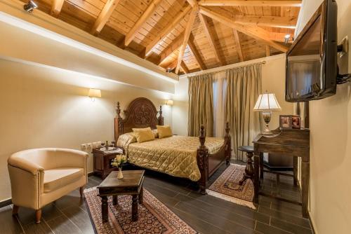a bedroom with a bed and a desk and a television at Theofilos Paradise Boutique Hotel in Mytilini