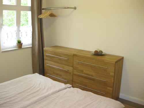 een slaapkamer met een houten dressoir en een bed bij Ferienwohnung Familie Böckmann im Ostseebad Zinnowitz auf Usedom in Zinnowitz