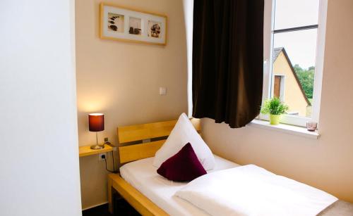 a small bedroom with a bed with a window at My Place in Lautzenhausen