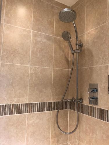 a shower with a shower head in a bathroom at Burlington House Guest House in Hunstanton