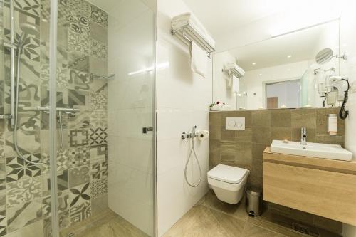 a bathroom with a shower and a toilet and a sink at Garni hotel Castle Bridge in Český Krumlov