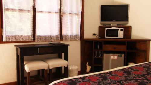 a bedroom with a bed and a tv and a table at Terrazas de Cruz Chica. in La Cumbre