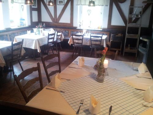 uma sala de jantar com mesas e cadeiras com velas em Zur Mühle em Mörlenbach