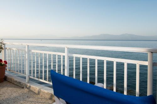 a blue couch on a balcony overlooking the ocean at Spacious apartment on the beachfront in Melission