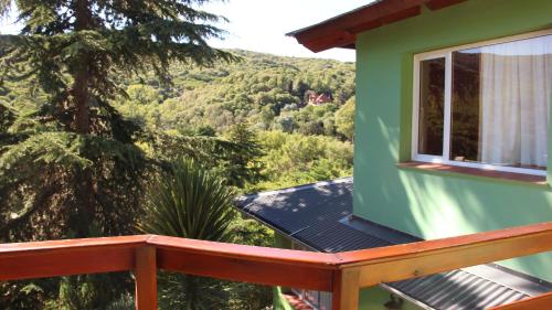 a green house with a balcony with a view at Terrazas de Cruz Chica. in La Cumbre