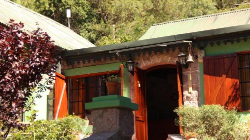 a house with an orange door and a green roof at Terrazas de Cruz Chica. in La Cumbre