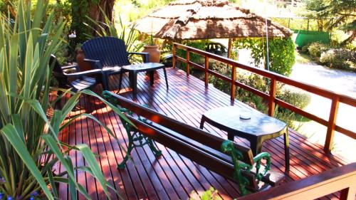 a deck with two chairs and a table and an umbrella at Terrazas de Cruz Chica. in La Cumbre